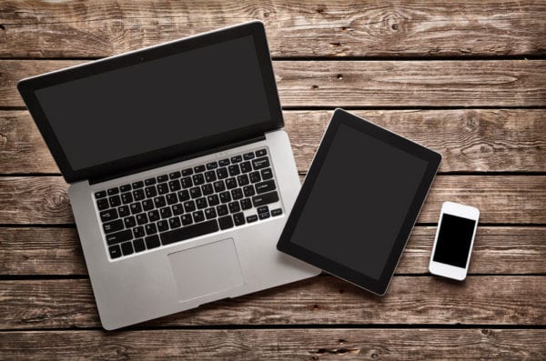 Software as a Service concept represented by an open laptop, tablet, and white smartphone on a desk.