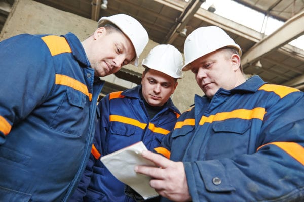 three industrial technicians discussing the results of previous maintenance work