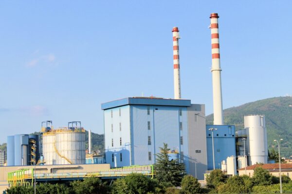 Factory exterior with smokestacks representing infrastructure repair and maintenance as part of MRO.