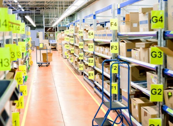 Inventory stockroom shelves labeled with bin number signs demonstrating inventory management