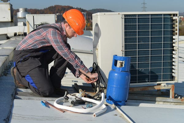 Maintenance technician performing preventive maintenance on a rooftop unit.