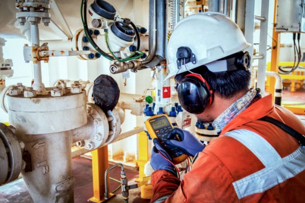 Technician using a calibration tool to perform time-based maintenance on a pipe system