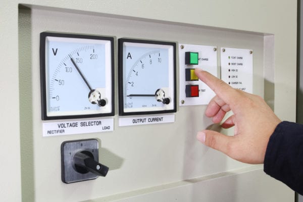 Maintenance person pressing a button on a voltage control panel in response to an alert from condition-based maintenance