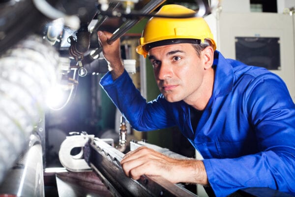 Technician inspecting machine to gather information and identify potential problems to troubleshoot.