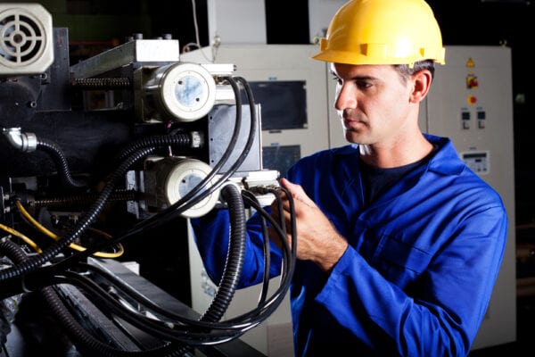 Young male technician troubleshooting machine to gather information and identify problems.