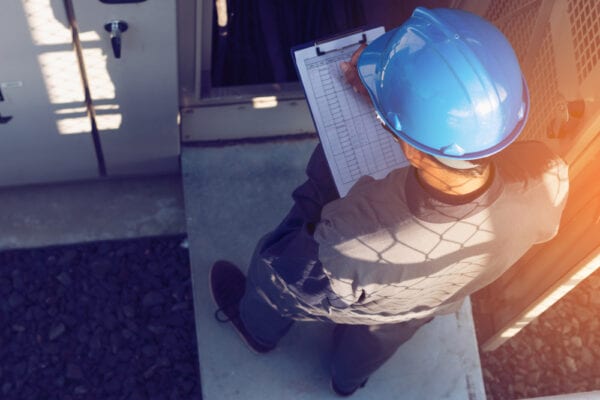 Facility maintenance technician performing a routine inspection as part of a proactive maintenance plan.