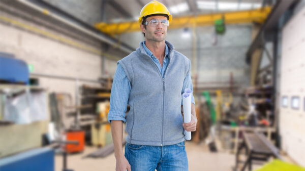 Middle-aged maintenance worker, selected a the project leader to implement a proactive maintenance plan, standing in a maintenance workshop.