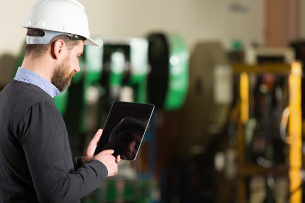 Man taking a picture of a lift truck with a rugged tablet computer.