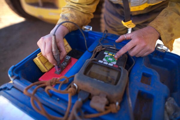 Maintenance technician testing a battery as part of preventive maintenance.