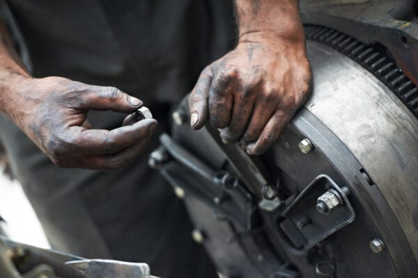 Mechanics hands examining a worn component, described on an equipment bill of materials (EBOM), in order to assess the severity of a machine’s condition.