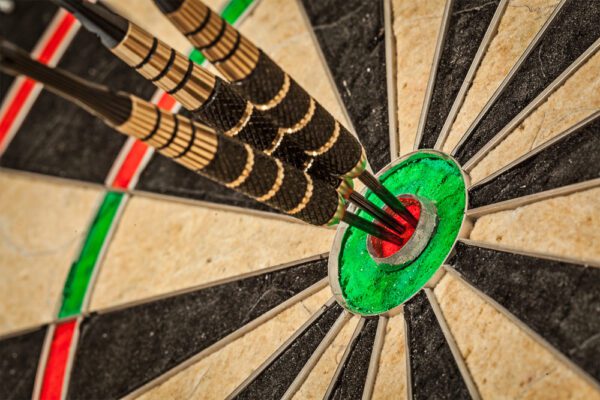 Dart board with three darts in the bullseye