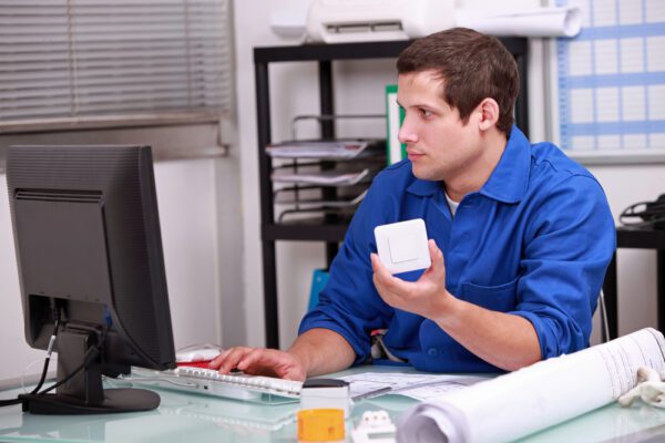 Man using computer to identify an inventory item to determine whether or not it is necessary to stock or is obsolete.