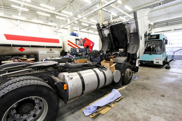 A commercial truck in a fleet being maintained before going back out on the road to deliver goods.