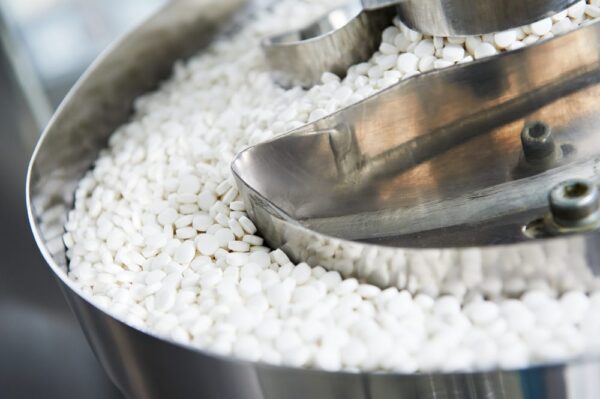Pills on a conveyor belt being produced by following FDA GMPs. 