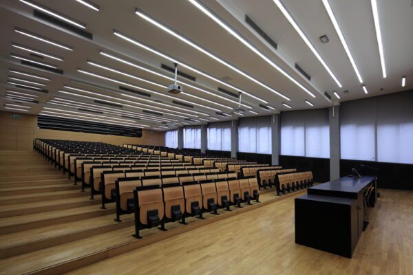 Illuminated lecture hall with fluorescent lights and projector.