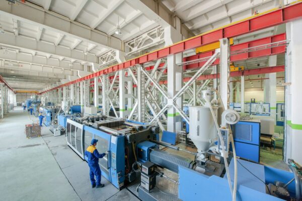 A maintenance technician performing maintenance on a large piece of equipment as part of asset management best practices.