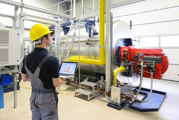 Young male technician monitoring an industrial boiler