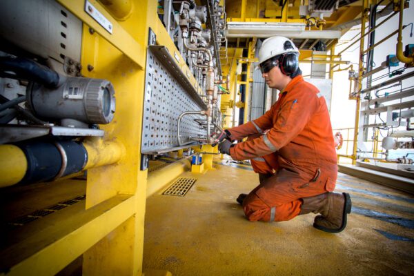 Maintenance worker checking pressure of a pipe and being tracked by productivity KPIs