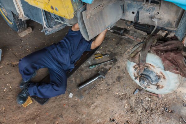 Maintenance technician ensuring the reliability of a construction vehicle by making a repair