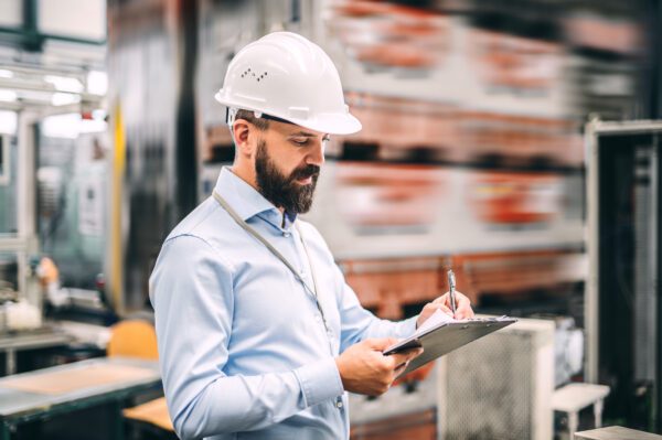 Maintenance supervisor holding a clipboard applying a work order authorization using a signature.