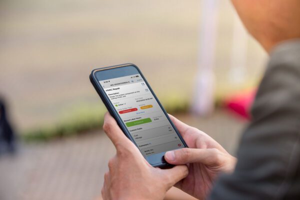 Maintenance technician looking at a work order on the FTMaintenance Select app on a smart phone.