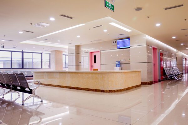 Hospital reception area with a large reception desk and seating for patients