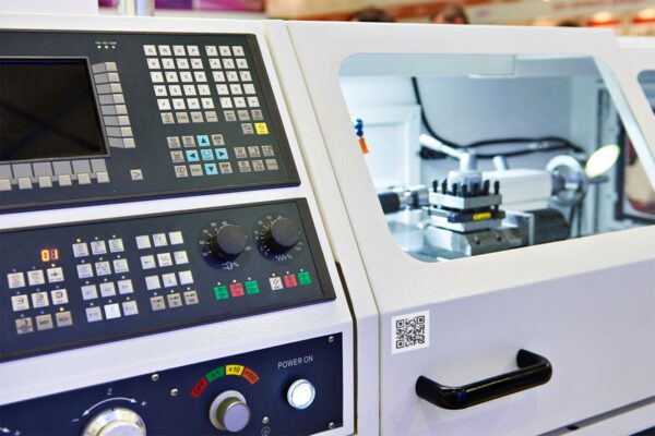 A CNC machine with a 2D barcode tag affixed to the exterior that can be scanned using barcode scanning technology.