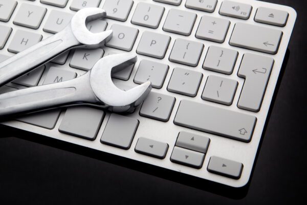 Close up of wrenches on a computer keyboard representing maintenance data.