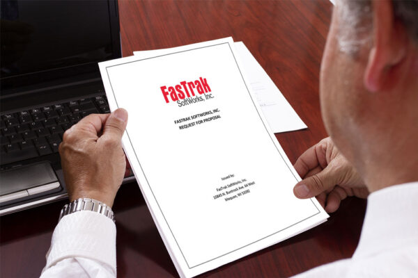 Close up shot of executive holding a CMMS RFP and looking at the cover page.