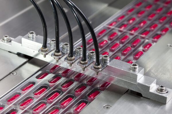 Close up shot of pharmaceutical drug production equipment that requires CMMS validation for maintenance purposes.