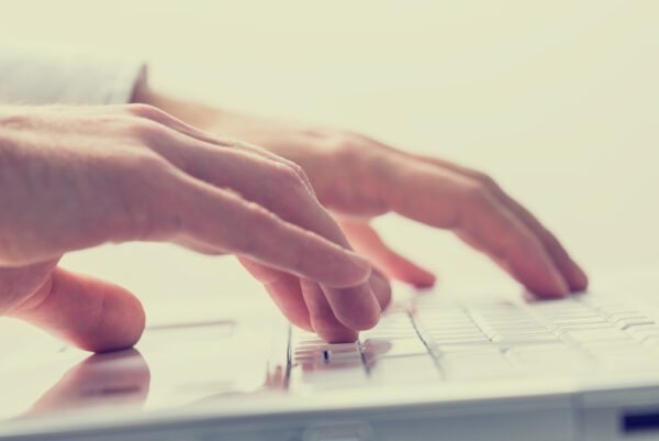 Close up of hands typing on a keyboard to represent digitized maintenance management.