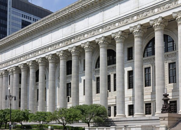Exterior of a government facility in New York State featuring limestone façade and Corinthian columns. 