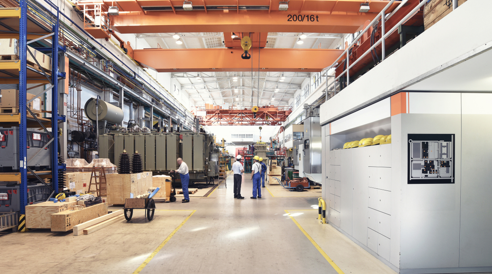 Industrial factory production hall with equipment, machinery, and technicians
