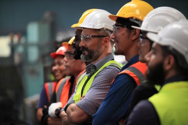 Medium-close shot of maintenance technicians, engineers, and industrial staff standing in a line.