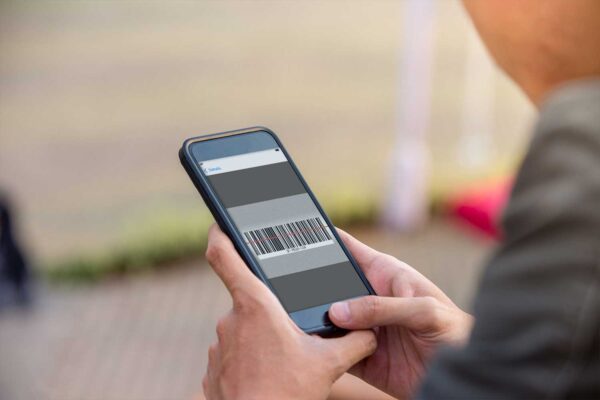 Close up of a technician’s hands using a smartphone to scan a barcode.