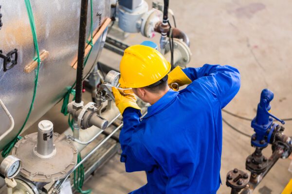 Top view of a maintenance technician performing a repair on factory equipment.