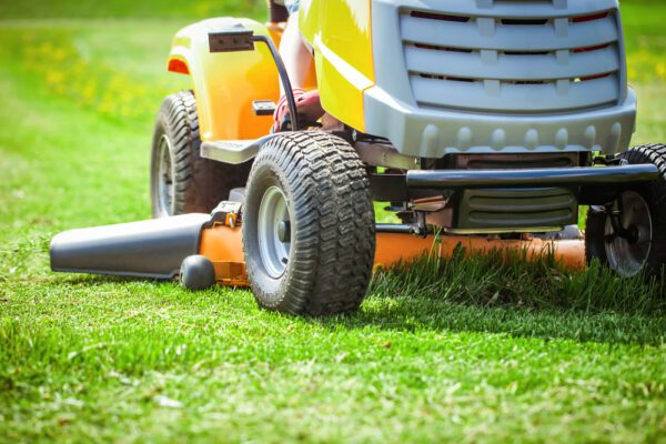 Close up of a riding lawnmower maintaining the lawn of a residential property