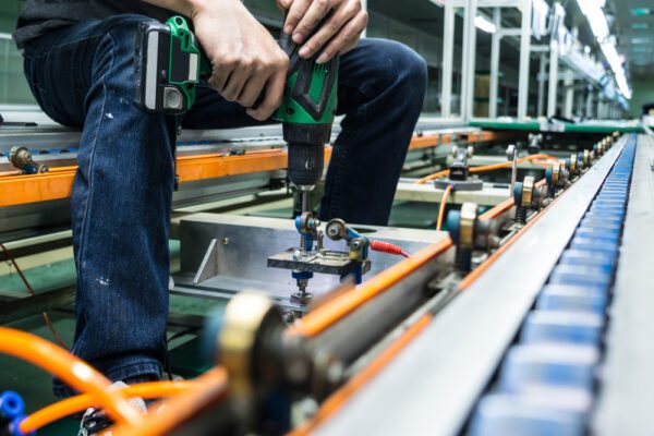 Close-up shot of maintenance technician repairing a conveyor system.