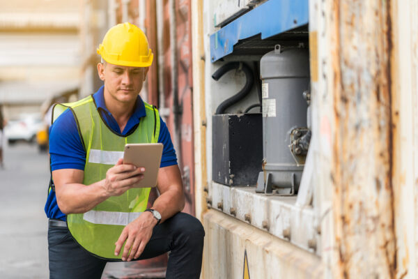 Maintenance technician performing an equipment inspection according to a checklist on a tablet computer.