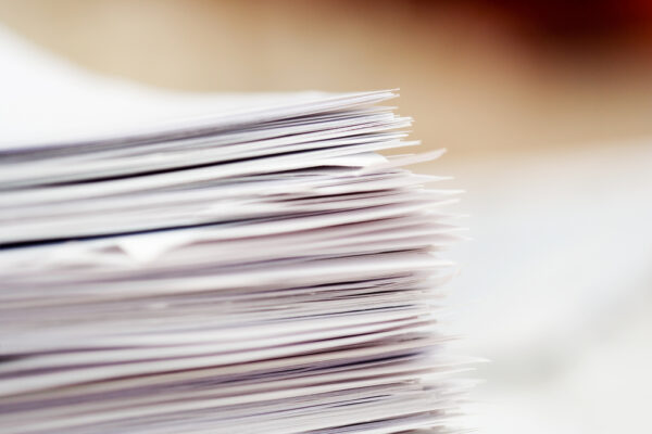 A stack of paper work orders from a side angle view.