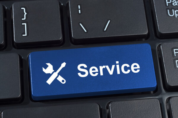 A close-up shot of a computer keyboard with a “service” button with a wrench and screwdriver.